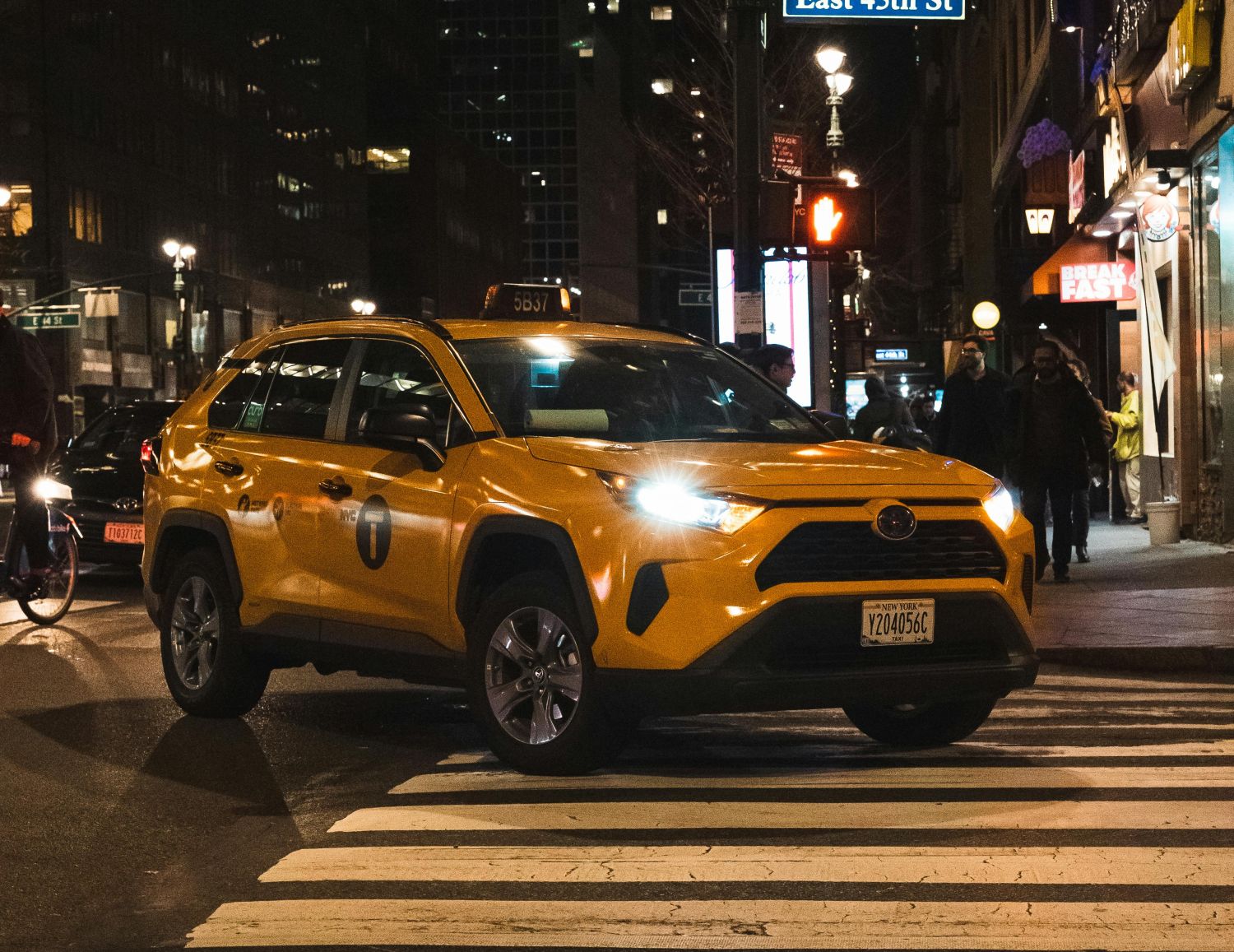 A taxi drives through an intersection