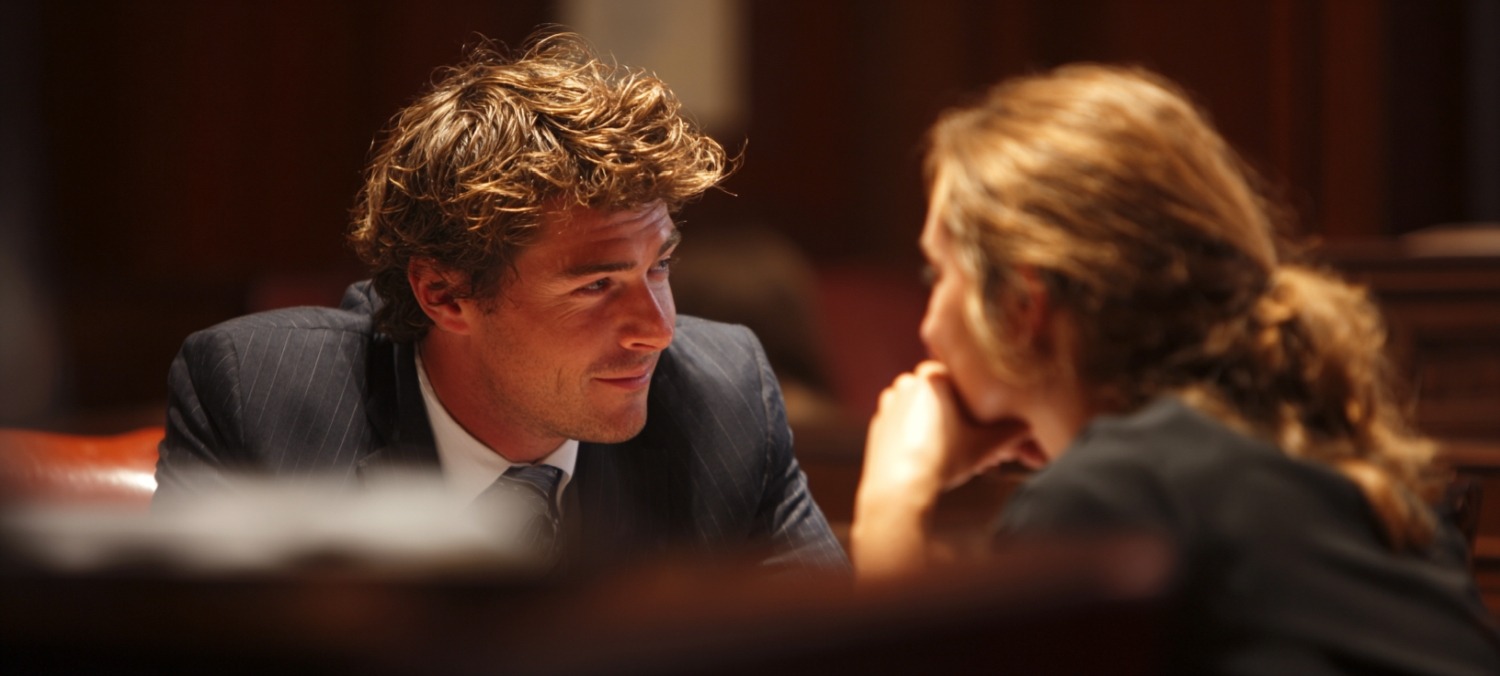 a personal injury lawyer and client whisper in a courtroom